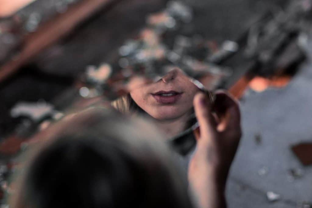 girl looking through a piece of mirror for a movie scene