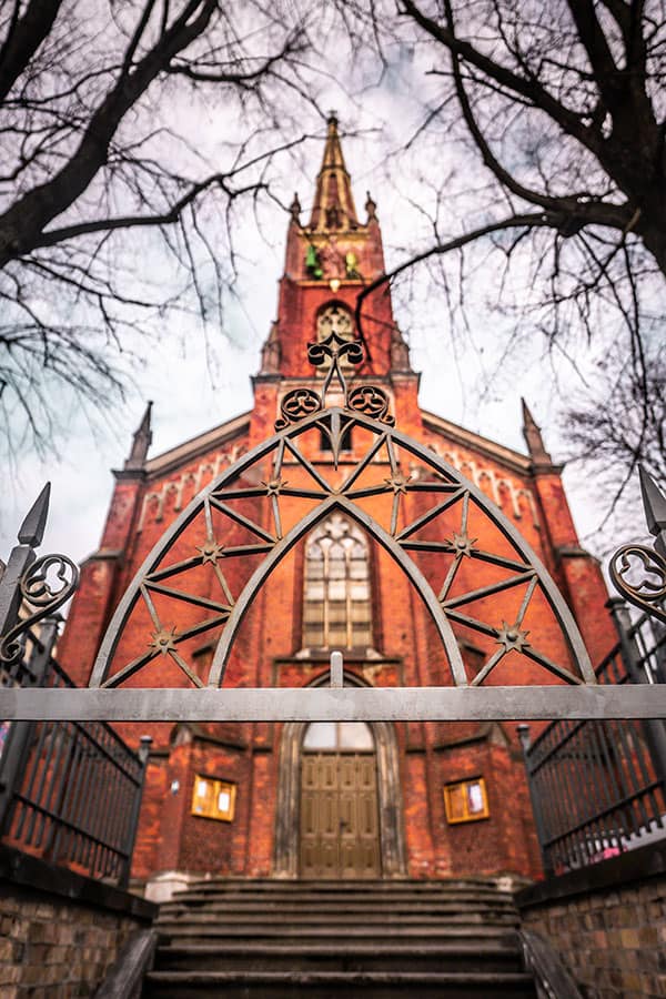 wide angle photo of a church with a metal portal in the foreground