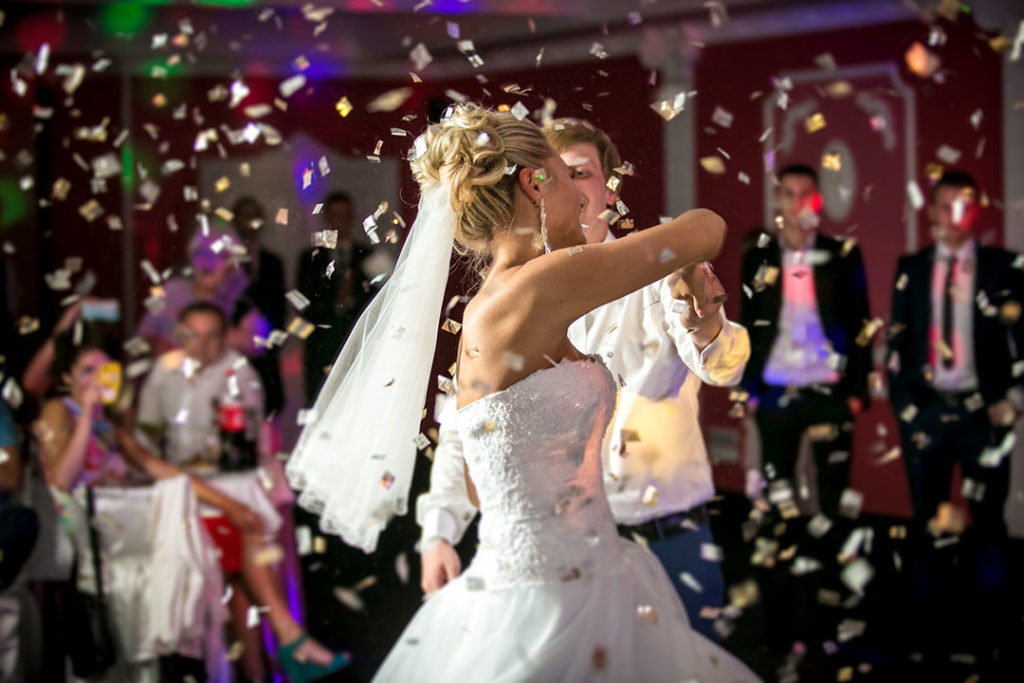 blonde bride dancing in flying confettis at a restaurant