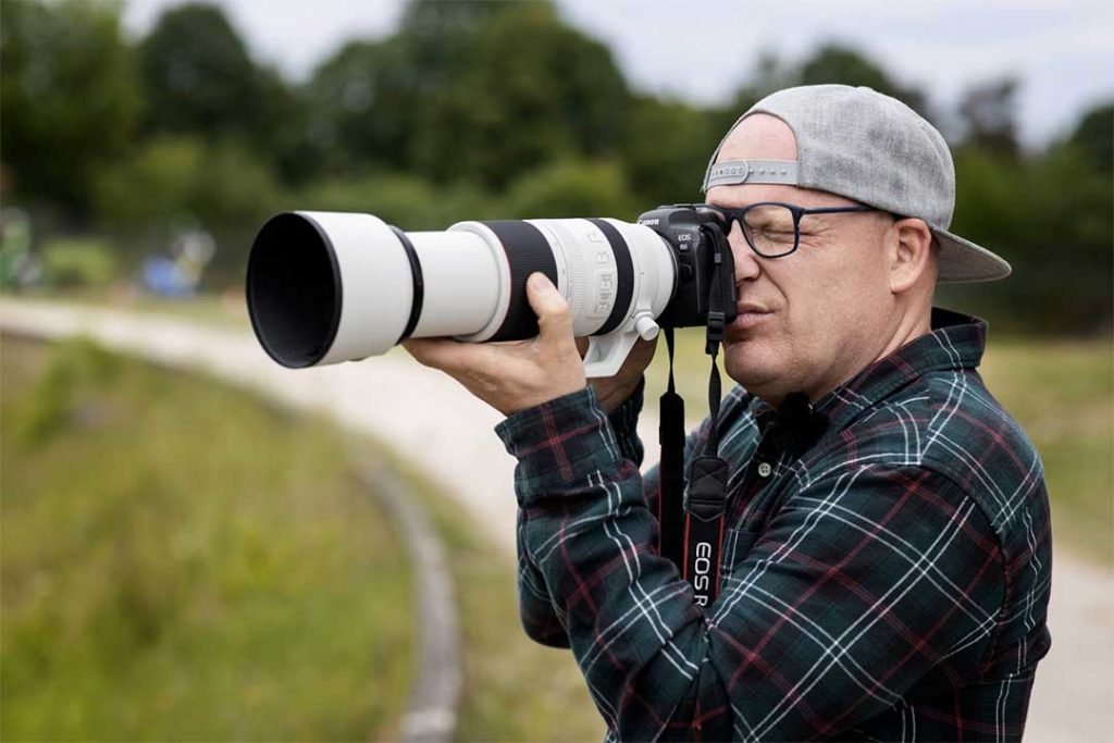 photographer reviewing the 100-500mm telephoto lens on a canon eos r6 camera